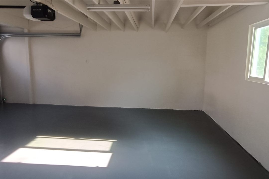 Finished garage interior with epoxy floor by ProMen Construction
