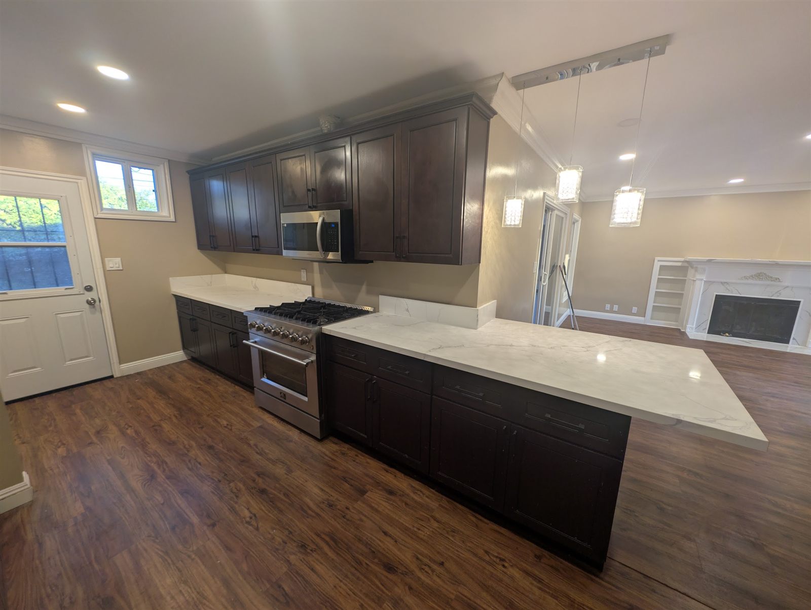 Completed kitchen remodel with dark cabinets and white countertops