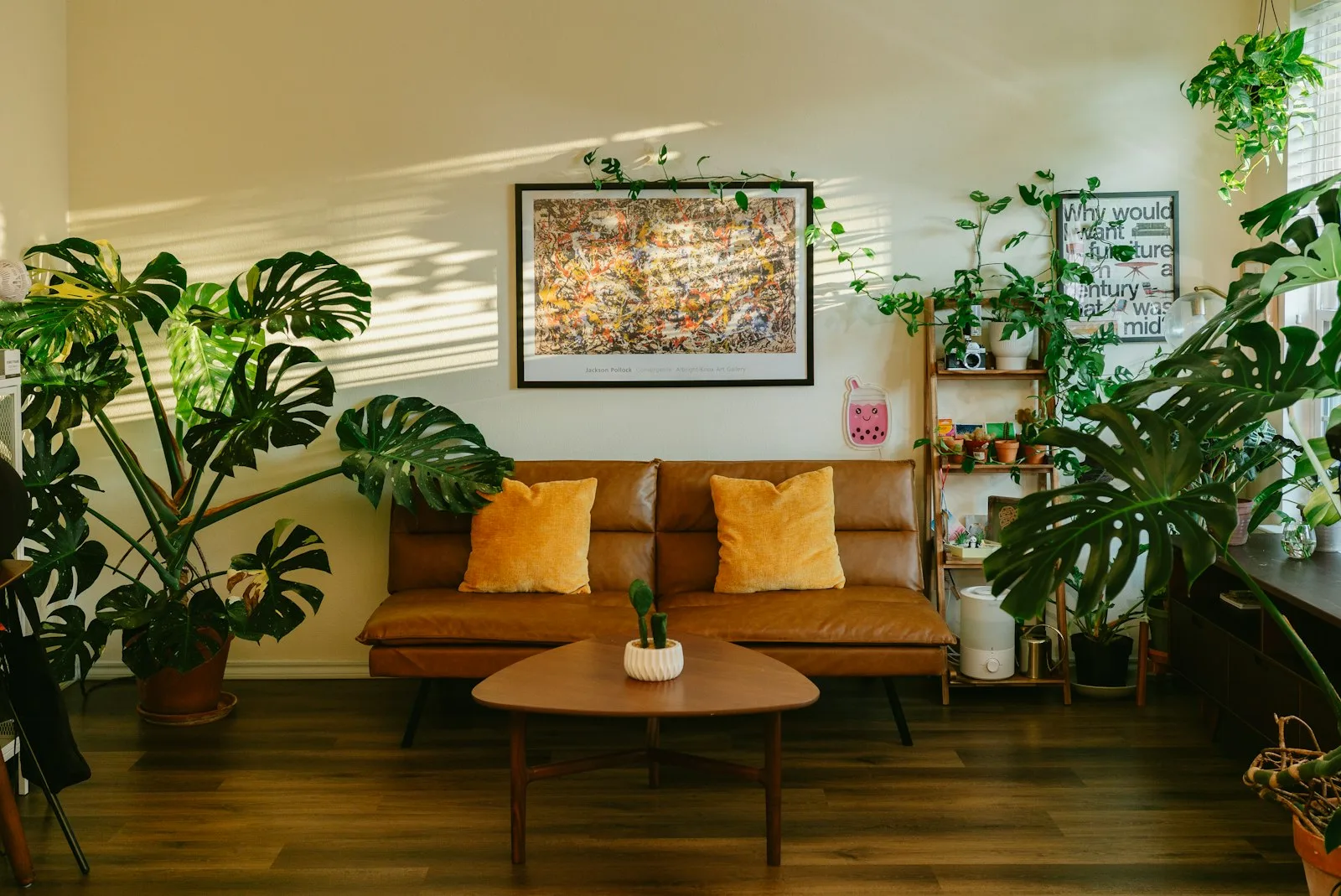 Sunlit living room with brown couch and lush plants