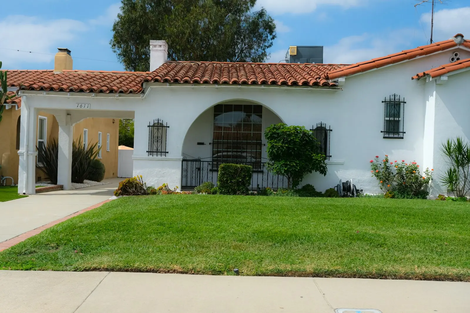 A white stucco house with a red tile roof