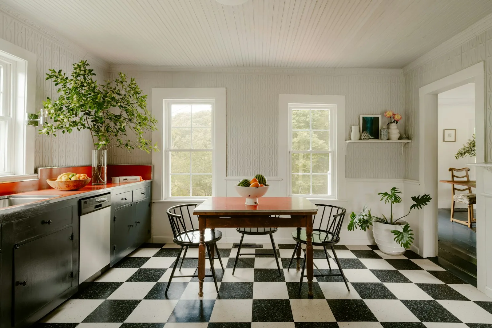 Bright kitchen with checkered floor, dining table, and large windows