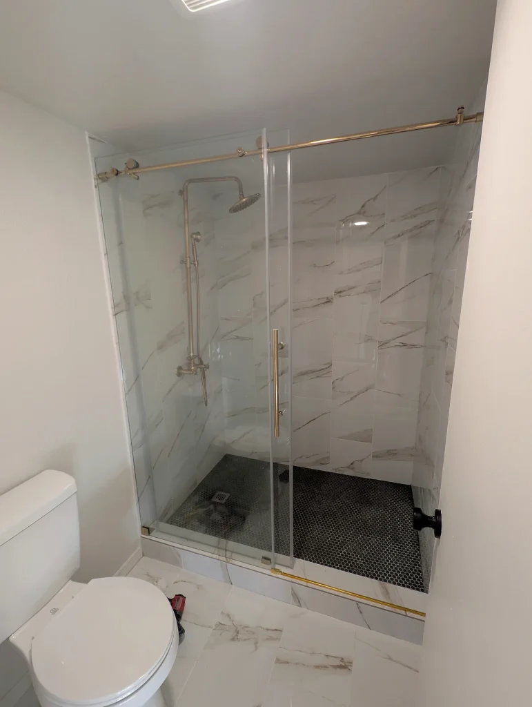 Shower Glass and Installed Fixtures — White Tile Shower & Bathroom