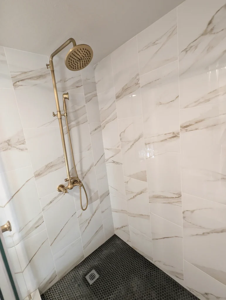 Shower Tile and Gold Fixtures Detail — White Tile Shower & Bathroom